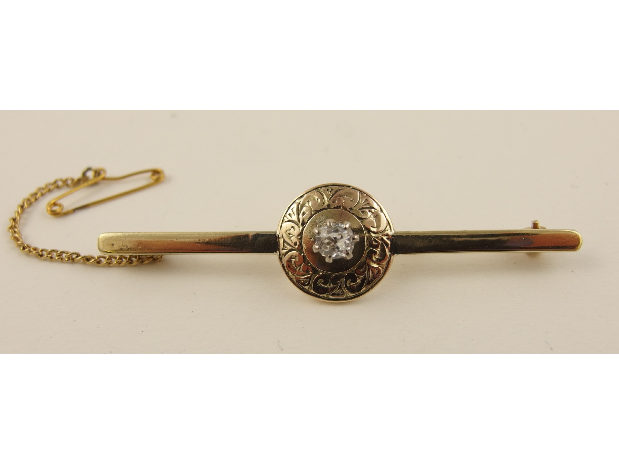 Appraisal: A yellow metal bar brooch with a central shield shape