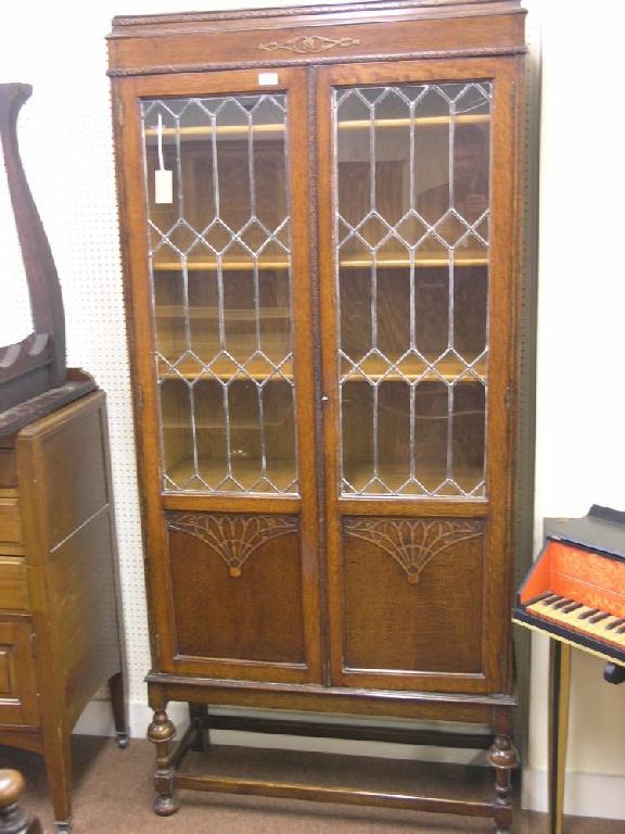 Appraisal: A 's medium oak display cabinet enclosed by a pair