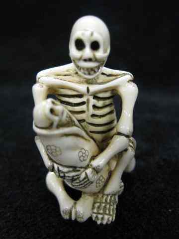 Appraisal: Carved Ivory Netsuke of a Skeletonholding a baby skeleton signed