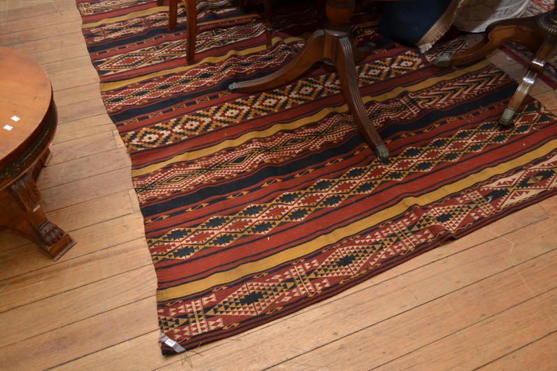 Appraisal: AN UZBEK KILIM RUG IN RED WHITE NAVY AND MUSTARD