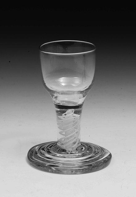 Appraisal: An th century dram glasswith ogee bowl double-series opaque twist