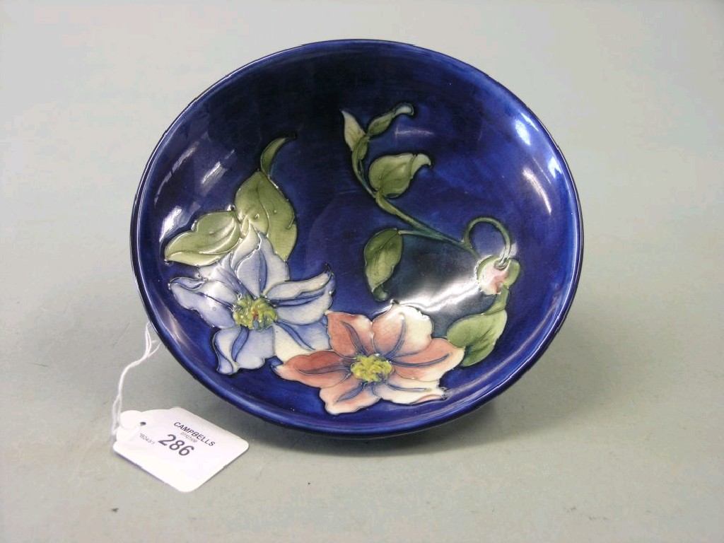 Appraisal: A Moorcroft stem dish painted with flowers against a deep