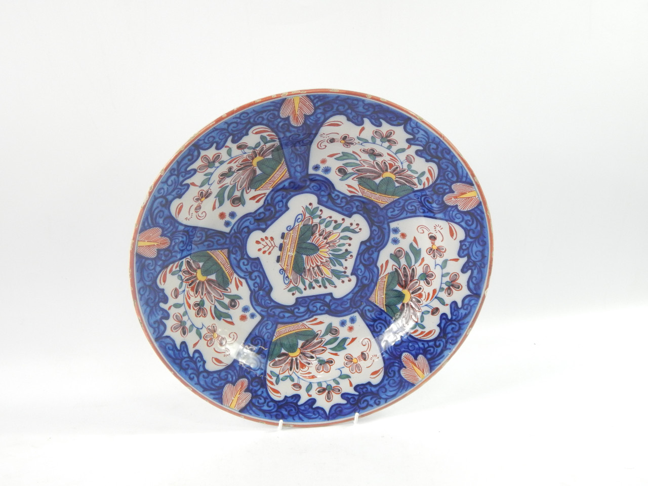 Appraisal: A Dutch delftware charger polychrome decorated with reserves of baskets