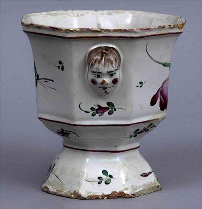 Appraisal: ROUEN-TYPE FAIENCE STEMMED OCTAGONAL URN With mask head handles and