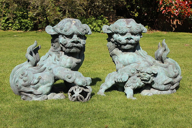 Appraisal: A PAIR OF CHINESE BRONZE DOGS OF FO one seated