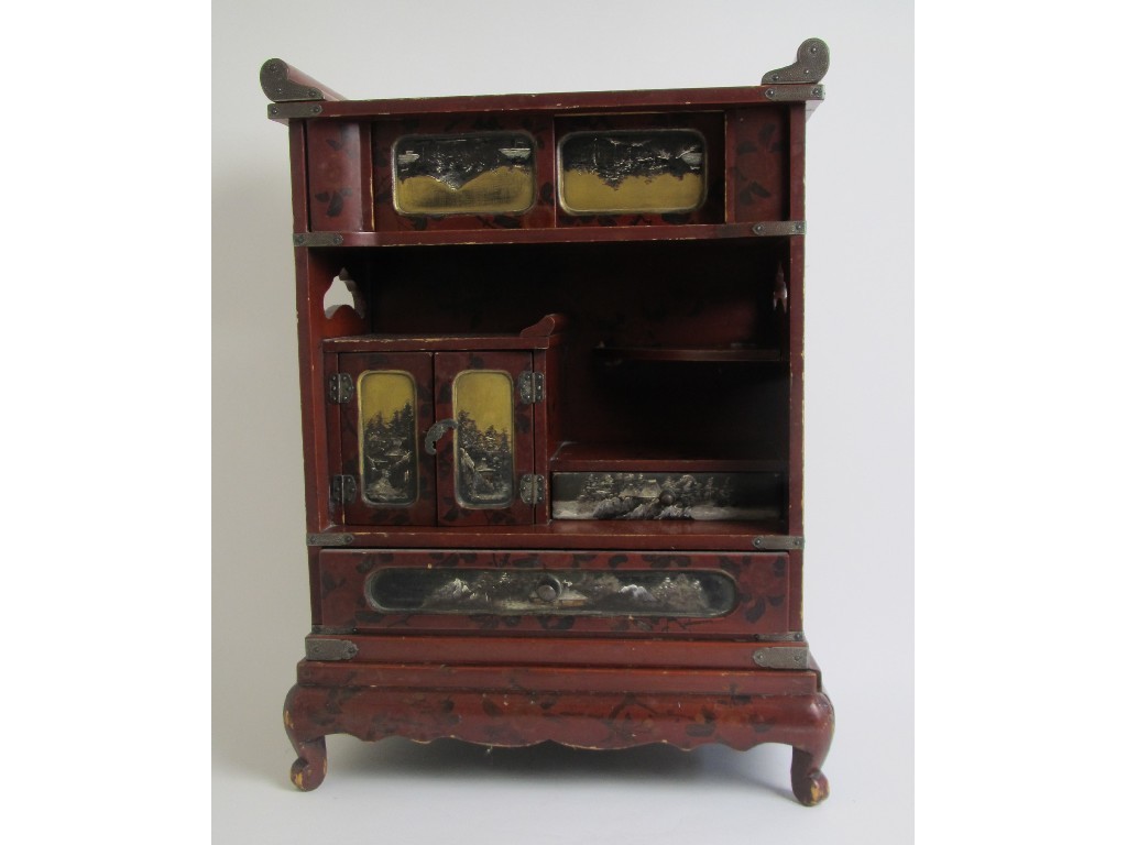 Appraisal: A Japanese red lacquer table cabinet painted with blossom above