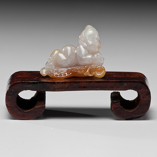 Appraisal: Chinese A white jade carving of a reclining boy russet