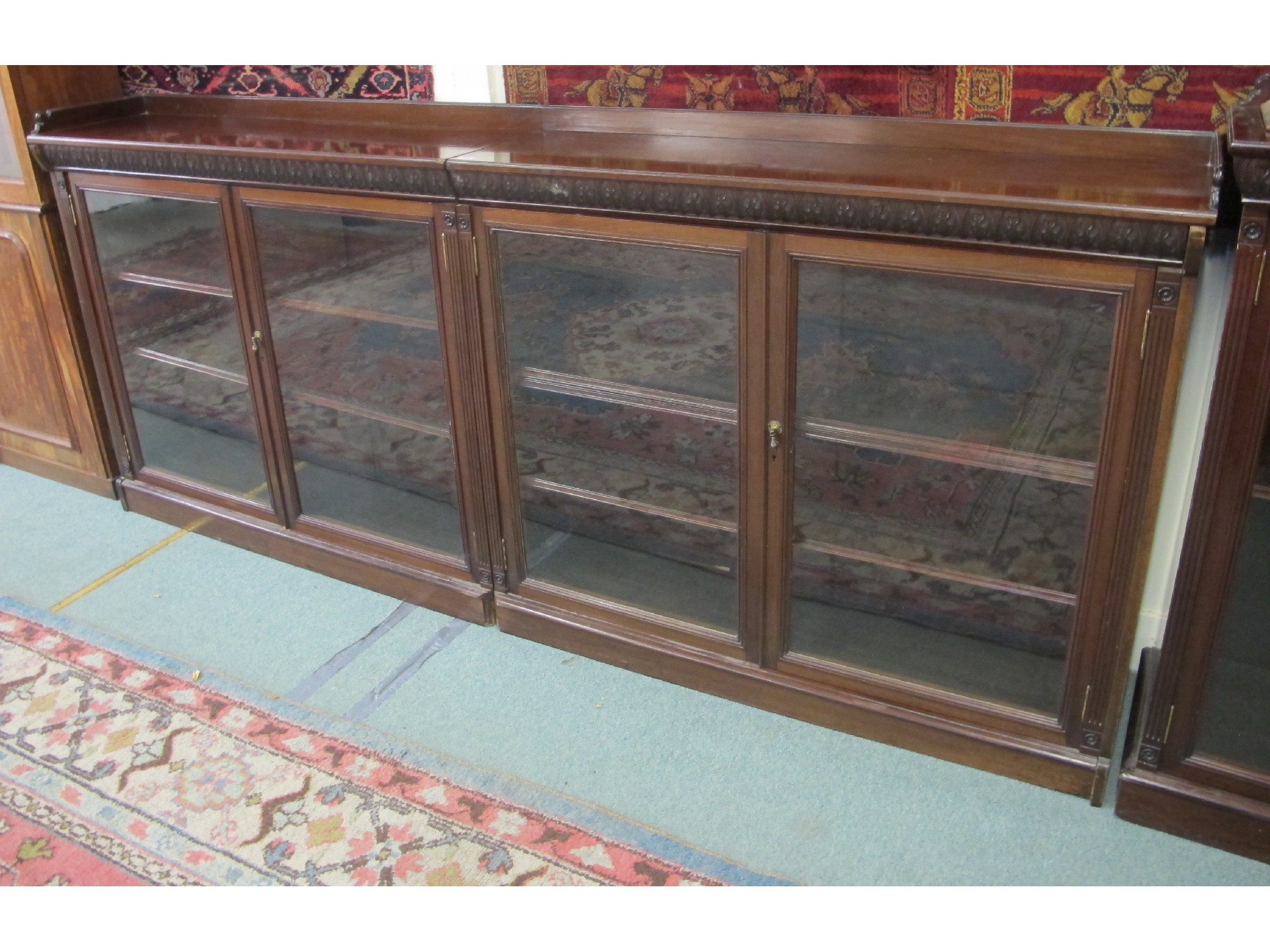 Appraisal: Low mahogany glazed four door bookcase with a similar glazed