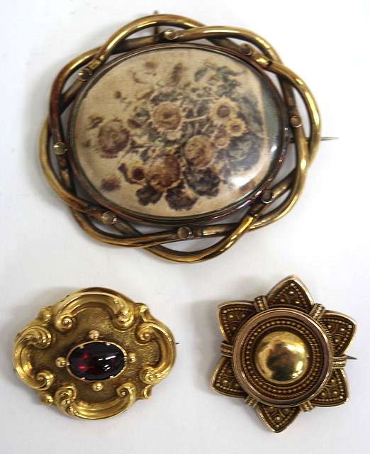 Appraisal: A VICTORIAN GILT METAL CABOCHON GARNET SET BROOCH of scrolling