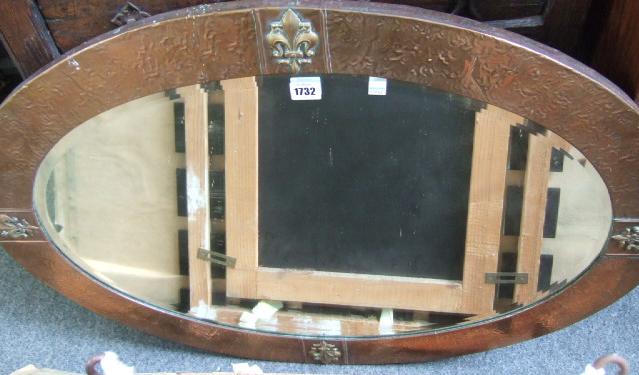 Appraisal: An oval Arts Crafts wall mirror with inset bevelled glass