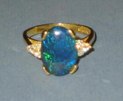 Appraisal: A BLACK OPAL AND DIAMOND RING the cabochon oval flanked