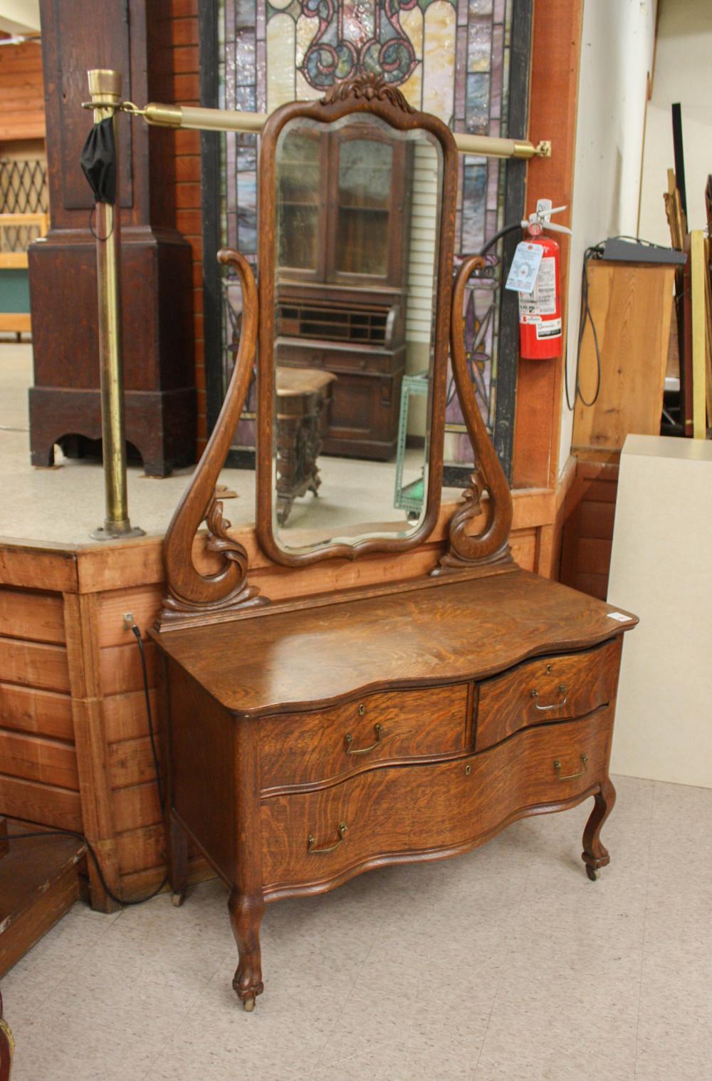 Appraisal: AN OAK LOW DRESSER WITH ATTACHED TILT MIRROR American c