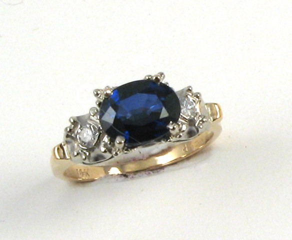 Appraisal: SAPPHIRE DIAMOND AND FOURTEEN KARAT GOLD RING centering an oval-cut