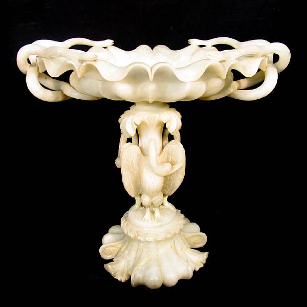 Appraisal: A carved alabaster bird bath with entwined serpent handles and