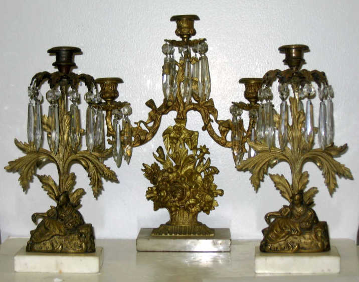 Appraisal: THREE VICTORIAN GILT BRASS CANDLESTICKS A three-light candelabrum in form