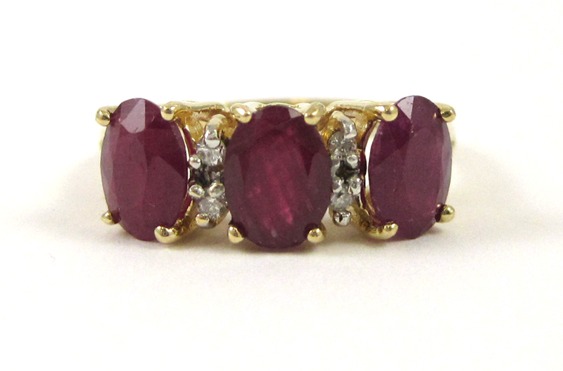 Appraisal: FOURTEEN KARAT GOLD RUBY AND DIAMOND RING having three oval-cut