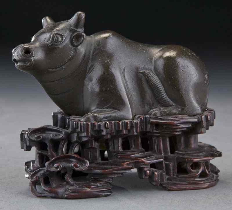 Appraisal: Chinese Qing bronze buffalo raised on a wood stand ''H