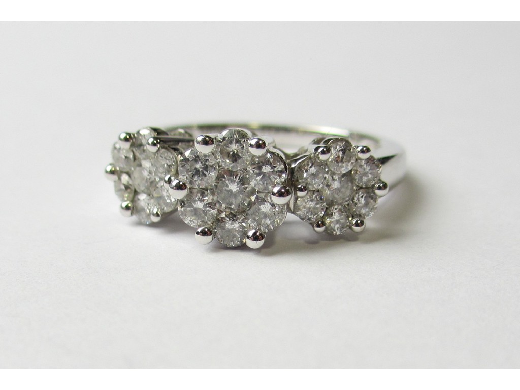 Appraisal: A fourteen carat white gold triple diamond cluster ring with