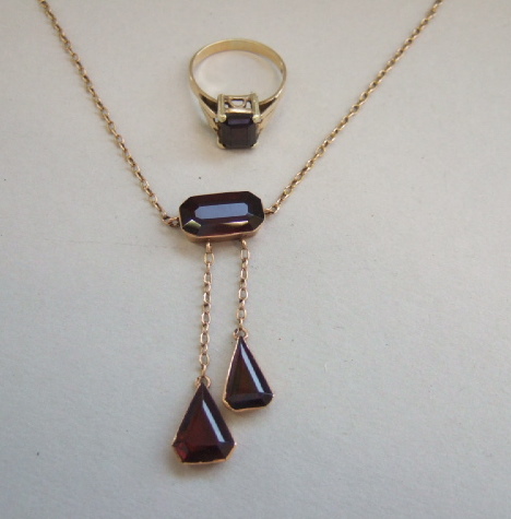 Appraisal: A gold and garnet set necklace the front mounted with