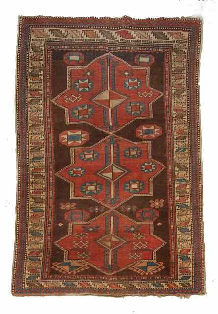 Appraisal: A CAUCASIAN BROWN GROUND RUG decorated three red ground central