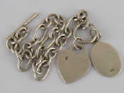 Appraisal: A white metal tests silver bracelet with a heart charm