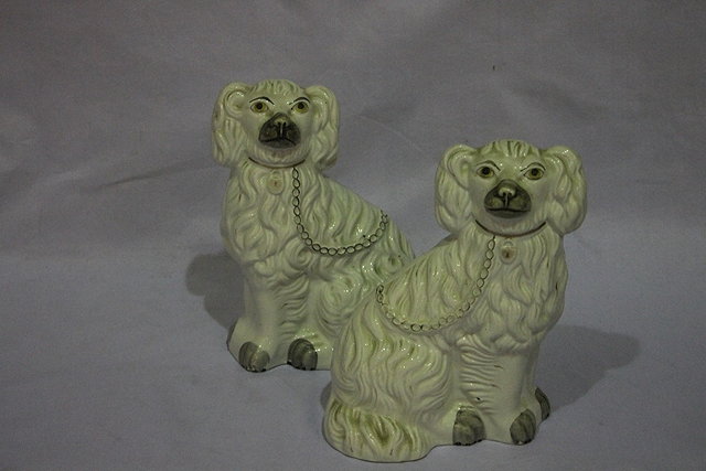 Appraisal: A PAIR OF STAFFORDSHIRE WHITE POTTERY MODEL SPANIELS cm high