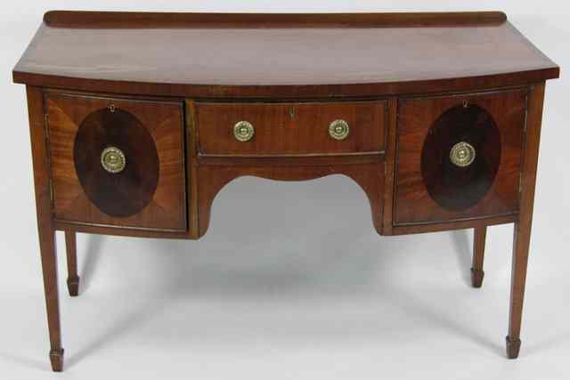 Appraisal: A mahogany bowfront sideboard fitted two cupboards and a central