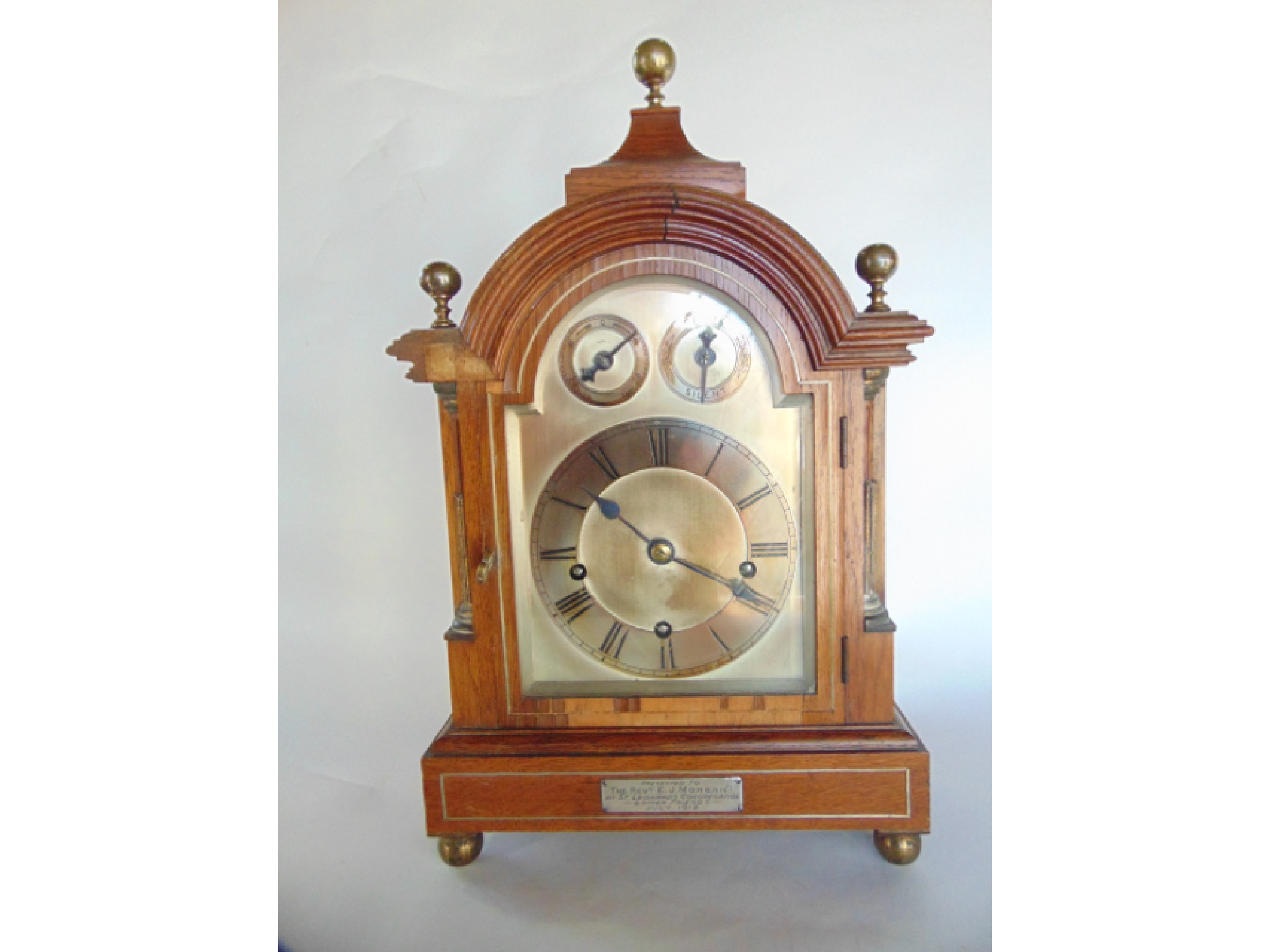 Appraisal: An Edwardian walnut veneered bracket clock with broken arch silvered