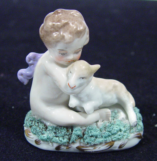 Appraisal: Continental porcelain figure of Putti clutching a lamb cm high