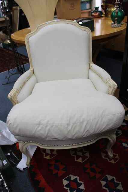 Appraisal: A POSSIBLY FRENCH CREAM PAINTED ARMCHAIR the carved frame overstuffed