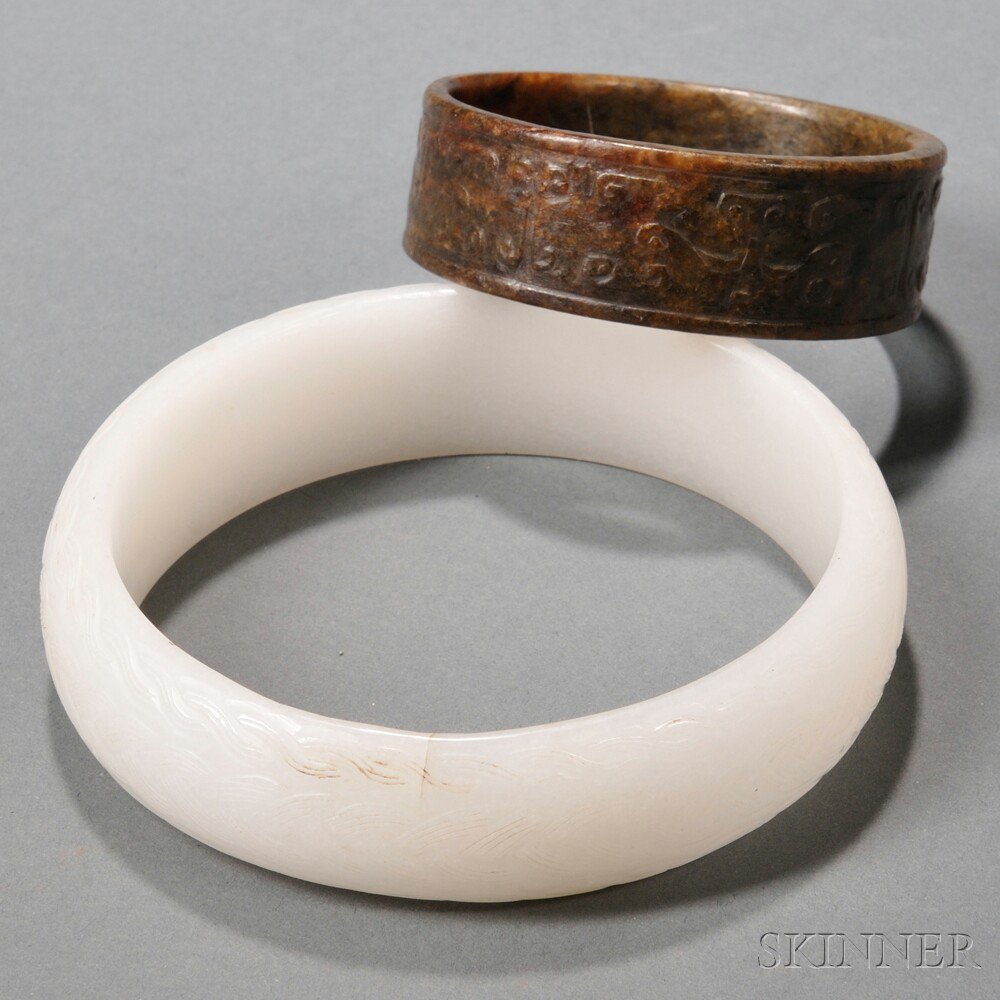 Appraisal: Two Hardstone Bangles China one brown with carved decoration on