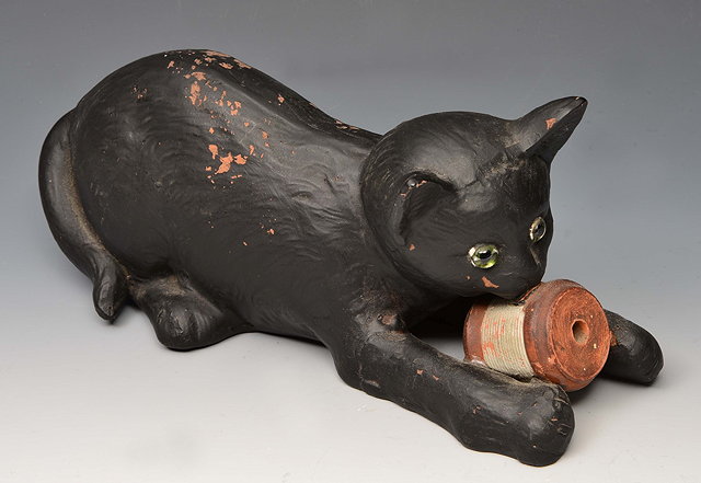 Appraisal: A BRETBY POTTERY BLACK CAT with cotton reel cm long