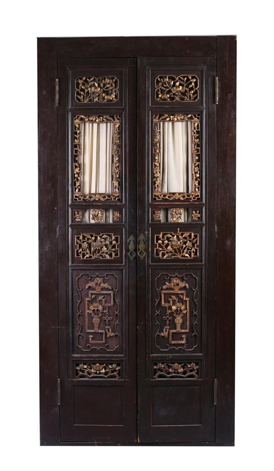 Appraisal: CHINESE CARVED EBONIZED AND GILT TWO-DOOR CABINET Upright rectangular cabinet