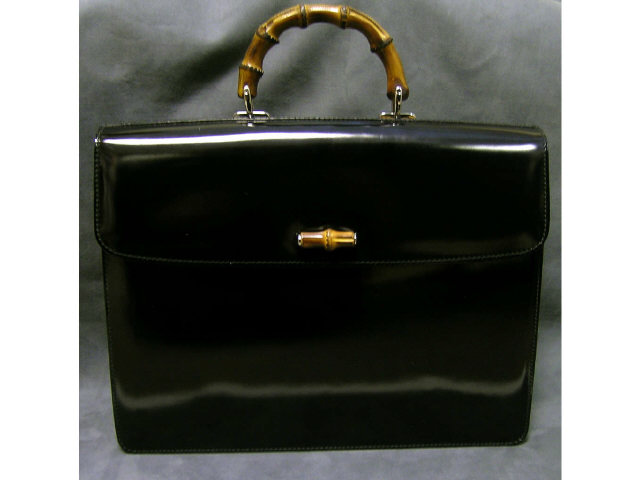 Appraisal: Gucci black patent briefcase with bamboo handle push snap flap