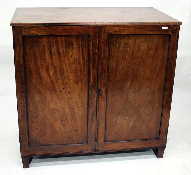 Appraisal: A GEORGIAN MAHOGANY LOW PRESS CUPBOARD with panelled doors opening