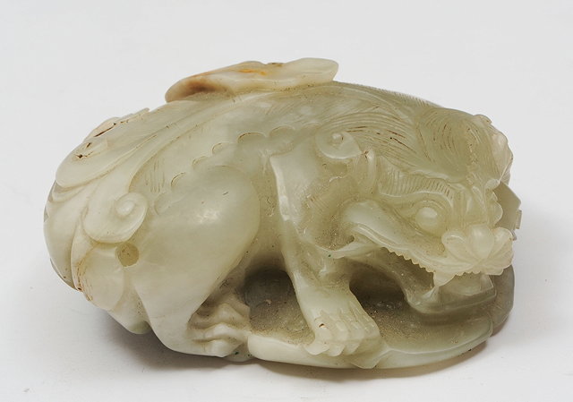 Appraisal: A CHINESE CARVED JADE MODEL of a recumbent lion th