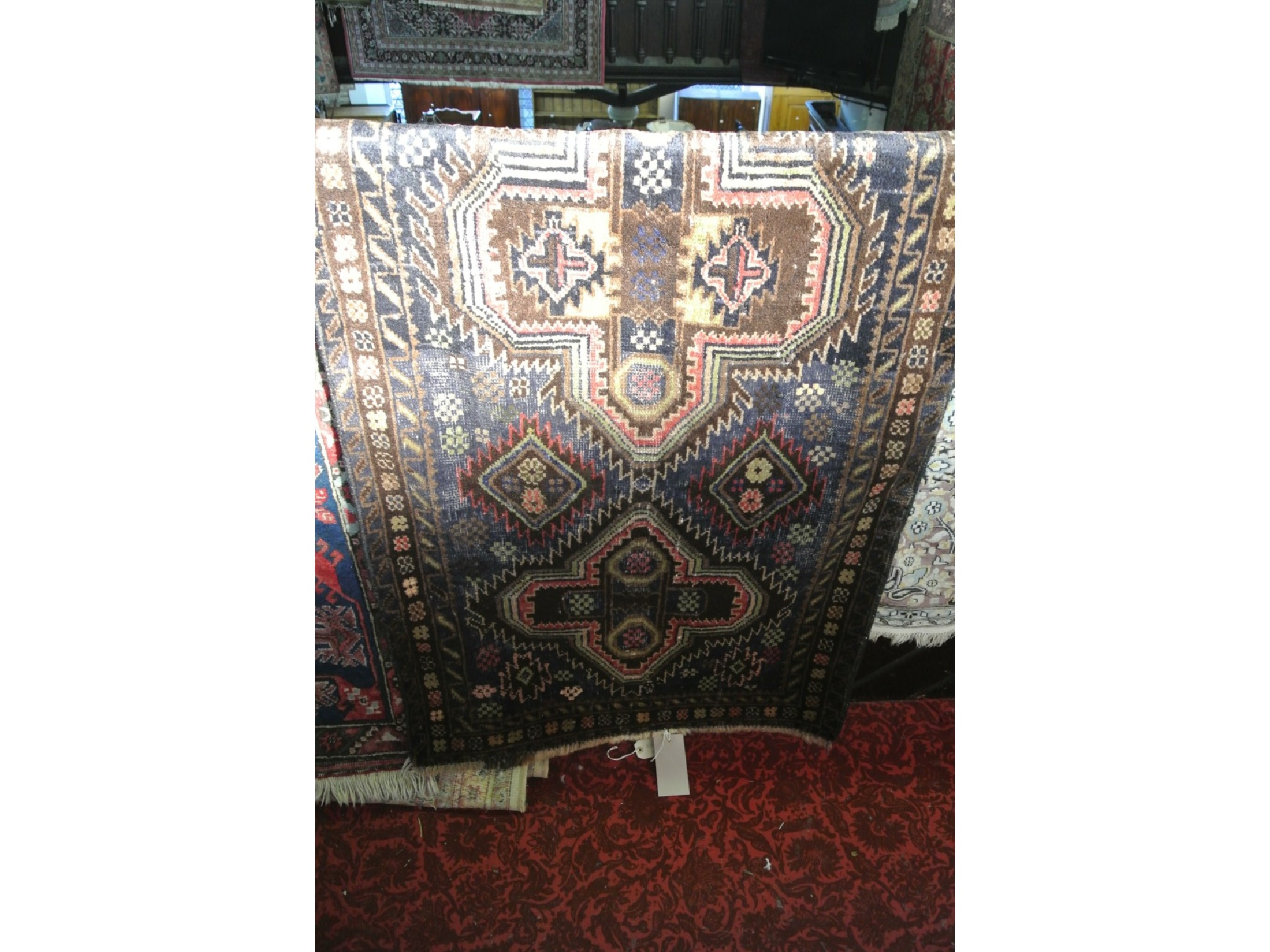 Appraisal: An eastern wool work rug with twin medallion centre upon