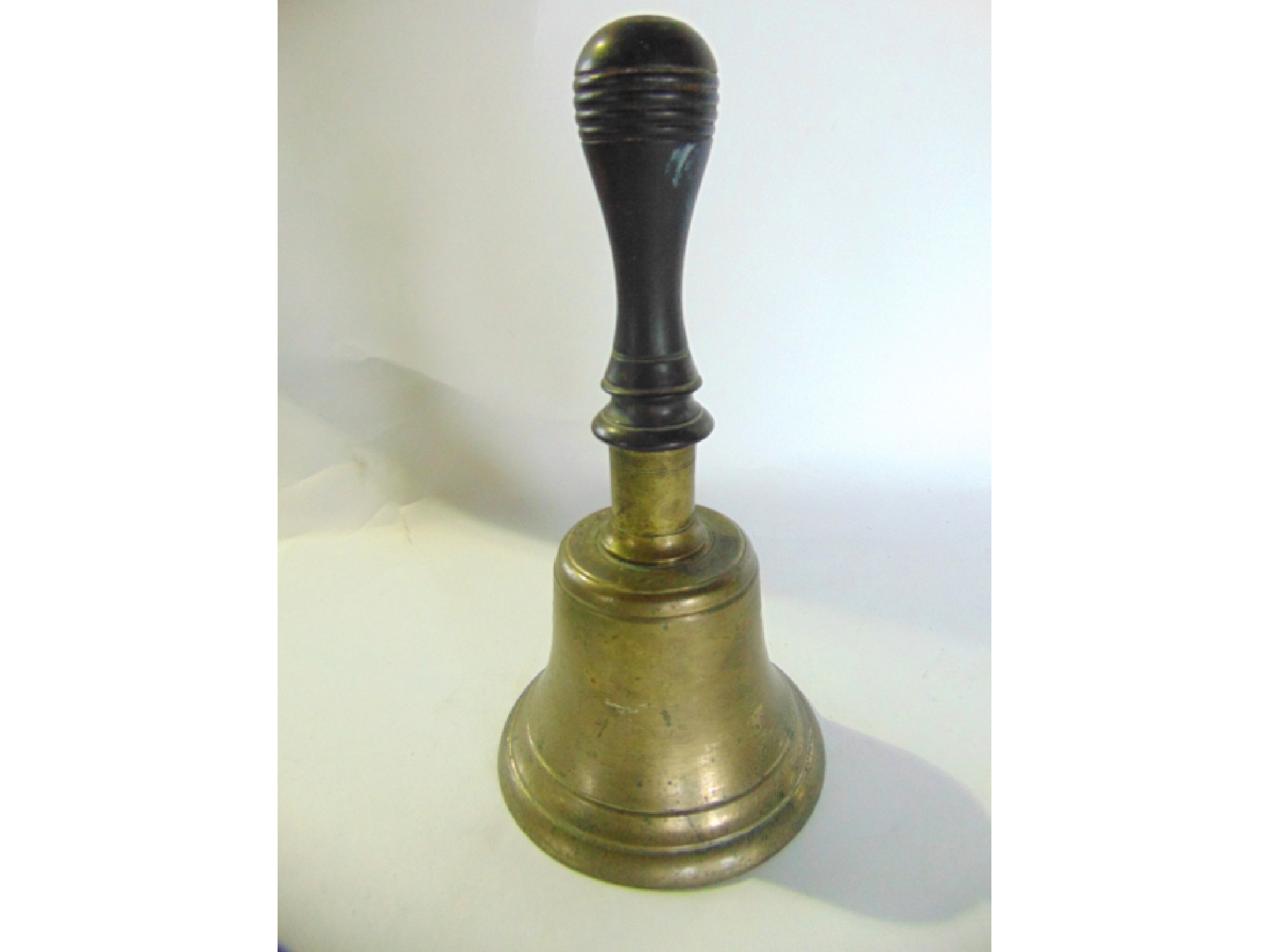 Appraisal: A cast metal schoolyard bell with turned timber handle