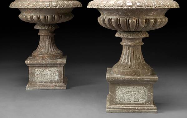 Appraisal: A pair of Neoclassical style carved marble urns With everted