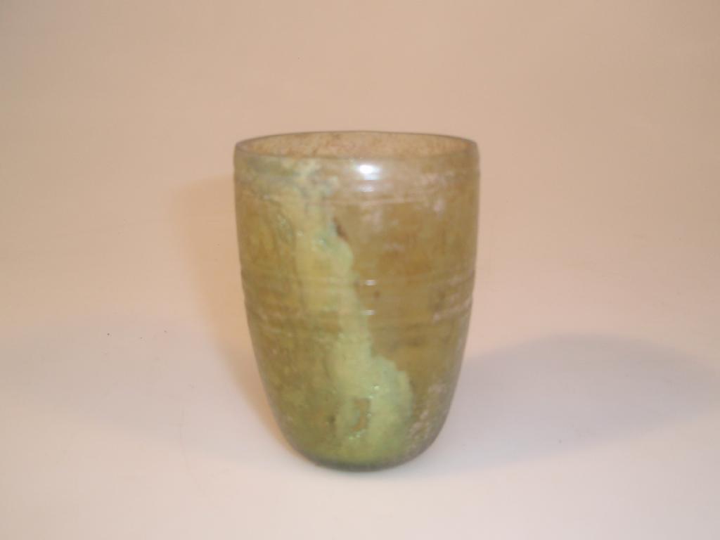 Appraisal: A Roman thick-walled yellowish-green glass beaker with a cut-off rim