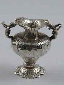 Appraisal: A small rococo style silver vase with putti forming the