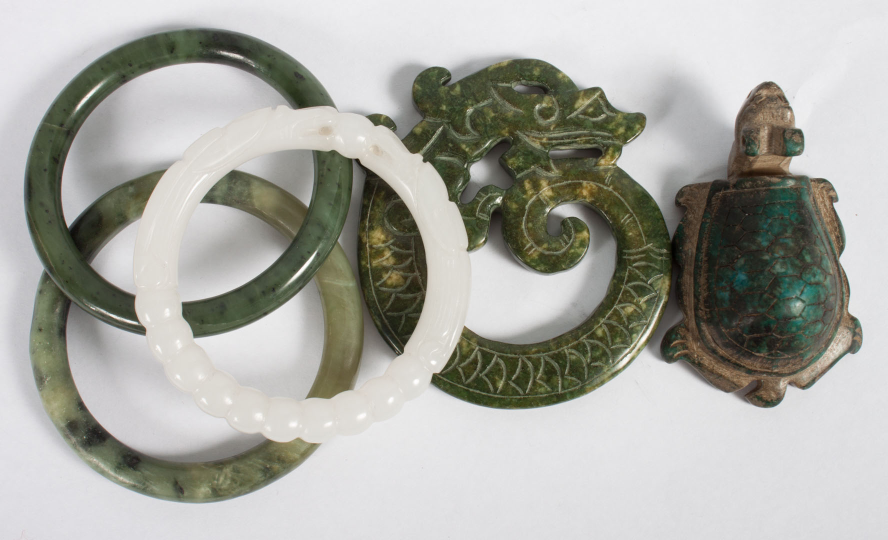 Appraisal: Four Chinese carved jade bangle bracelets and a fanciful beast