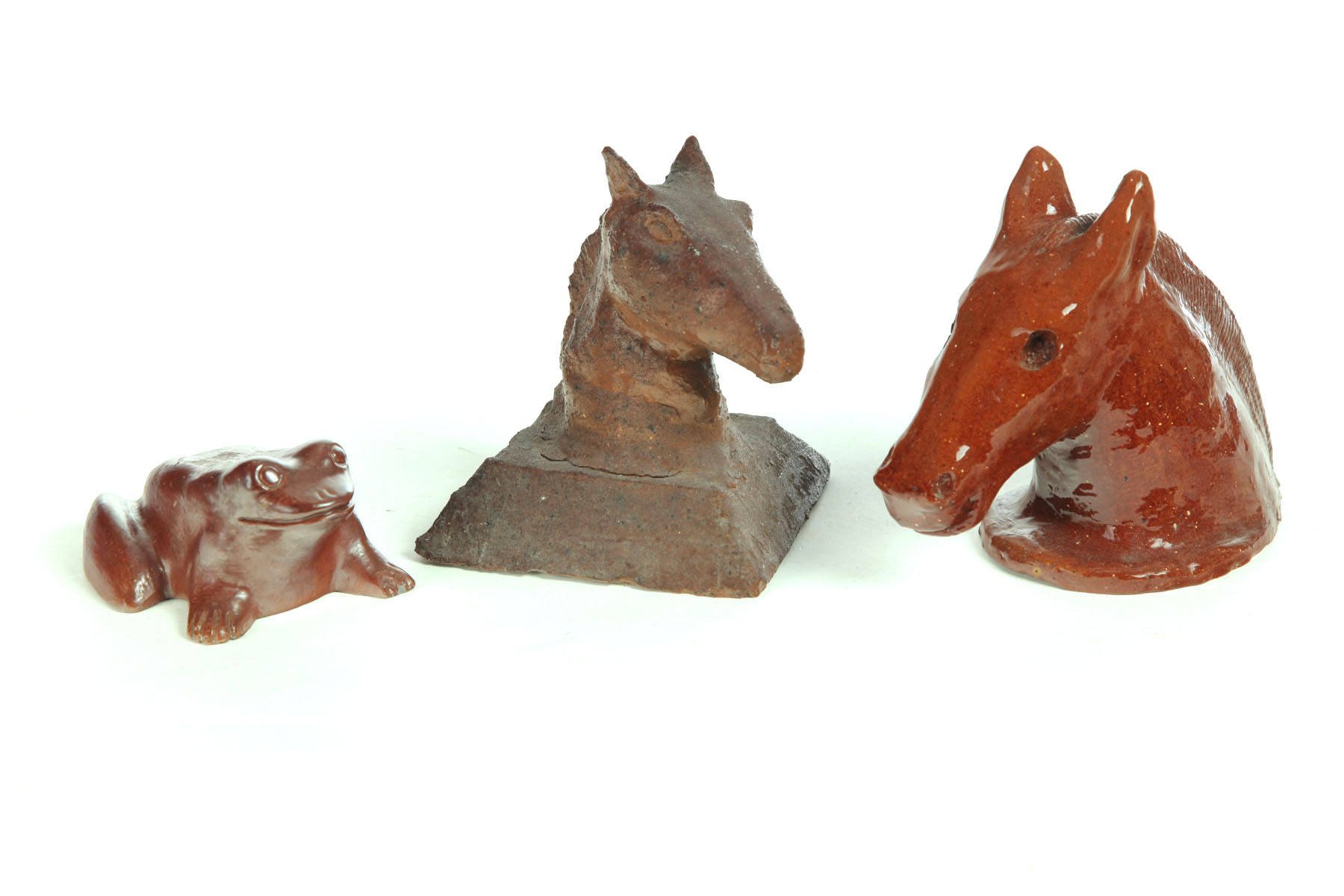 Appraisal: THREE SEWERTILE ANIMALS American th century Two horse heads one