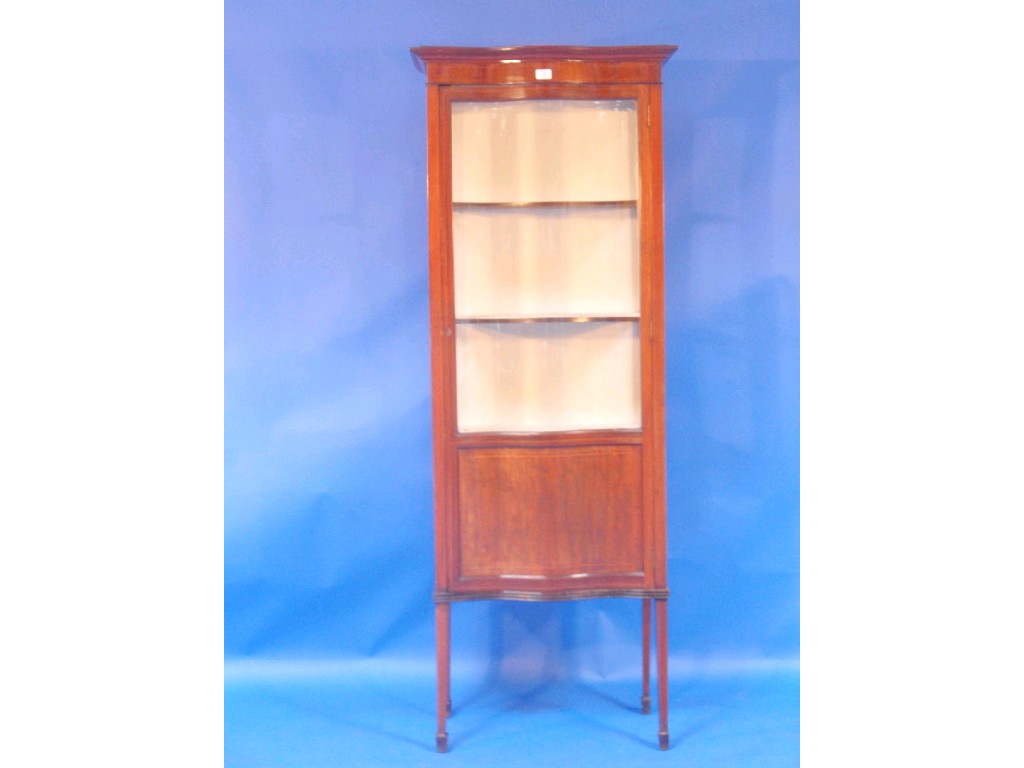 Appraisal: An Edwardian string inlaid mahogany display cabinet of serpentine form