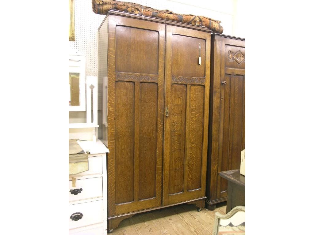 Appraisal: A dark oak wardrobe pair of full-length panelled doors enclosing