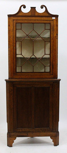 Appraisal: AN OAK FLOOR STANDING CORNER CUPBOARD the glazed upper section