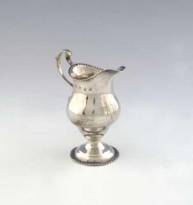 Appraisal: A George III helmet cream jug on a pedestal foot