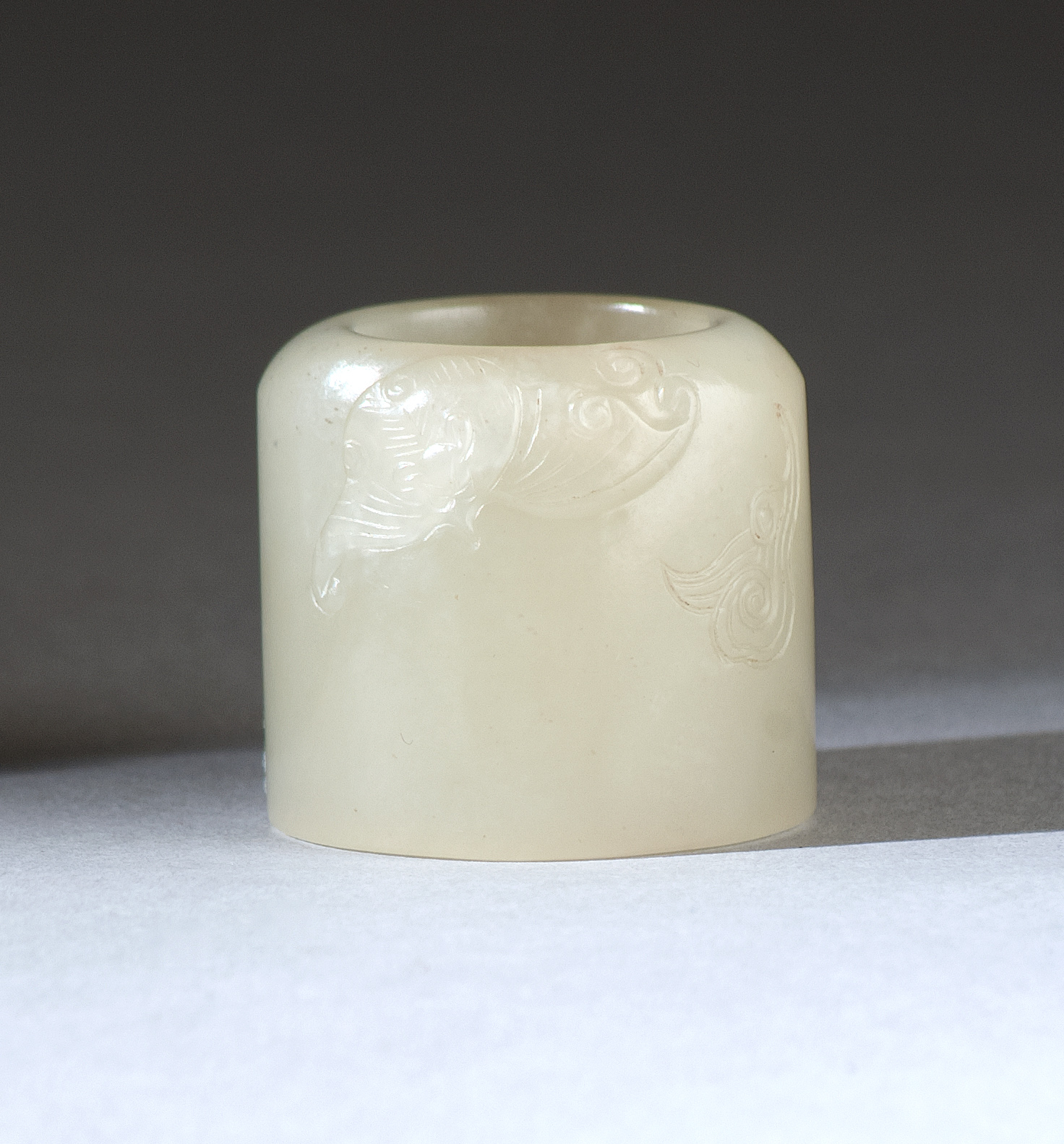 Appraisal: WHITE JADE THUMB RING th CenturyWith bat and ruyi carving