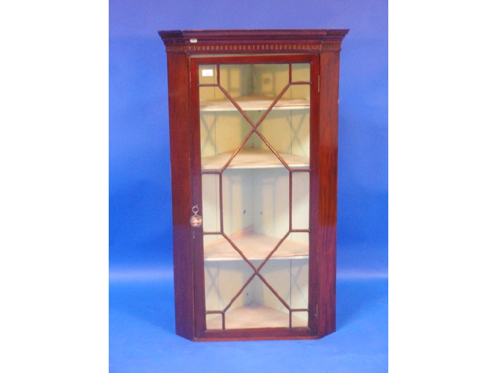 Appraisal: An antique mahogany hanging corner cabinet with moulded and dentil