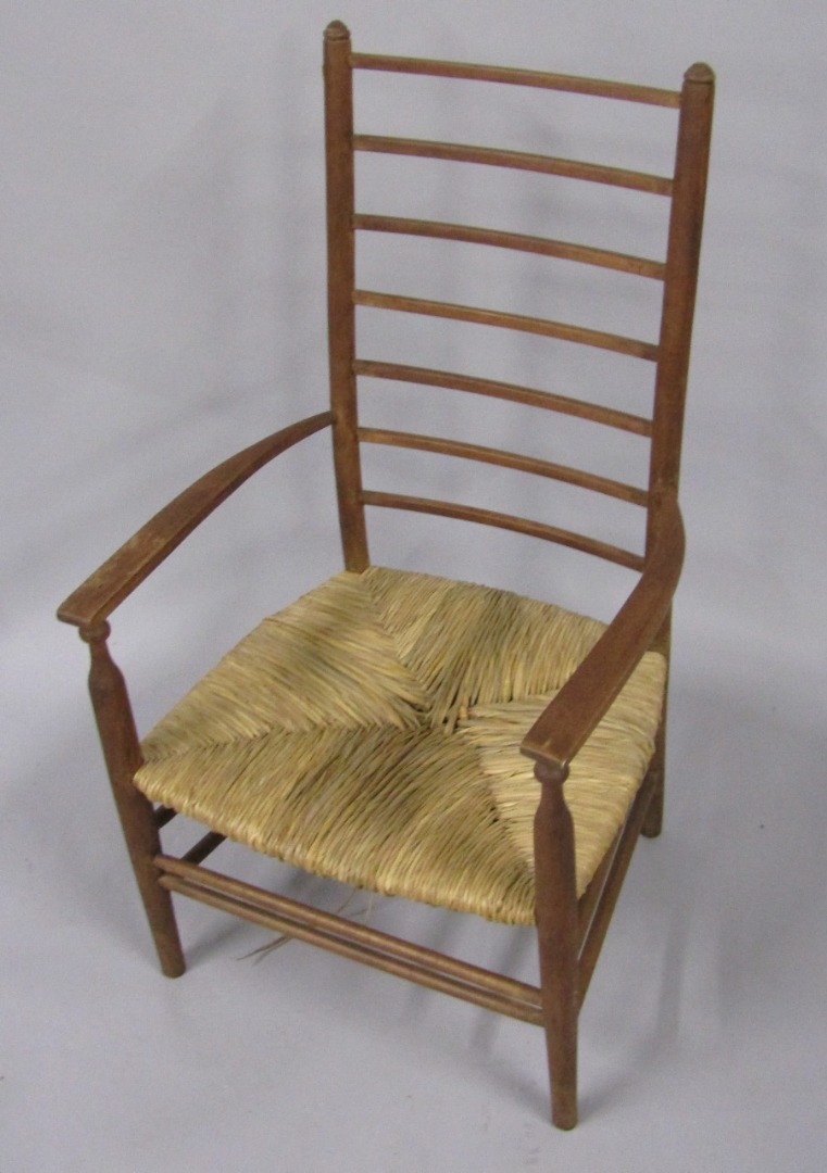 Appraisal: An early thC oak ladderback nursing chair with rush seat